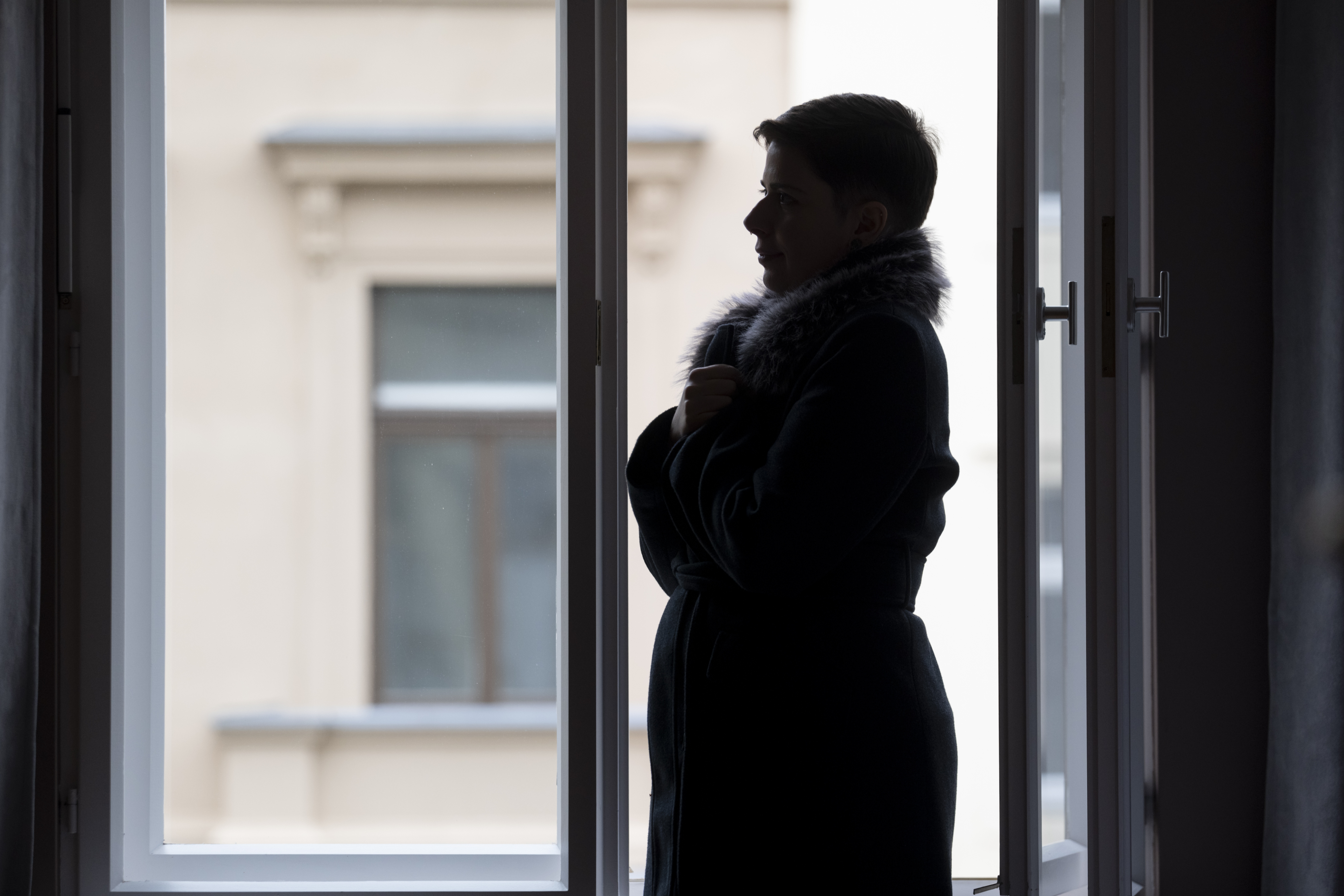 Rachel Gregors Shilouette steht vor offenem Fenster