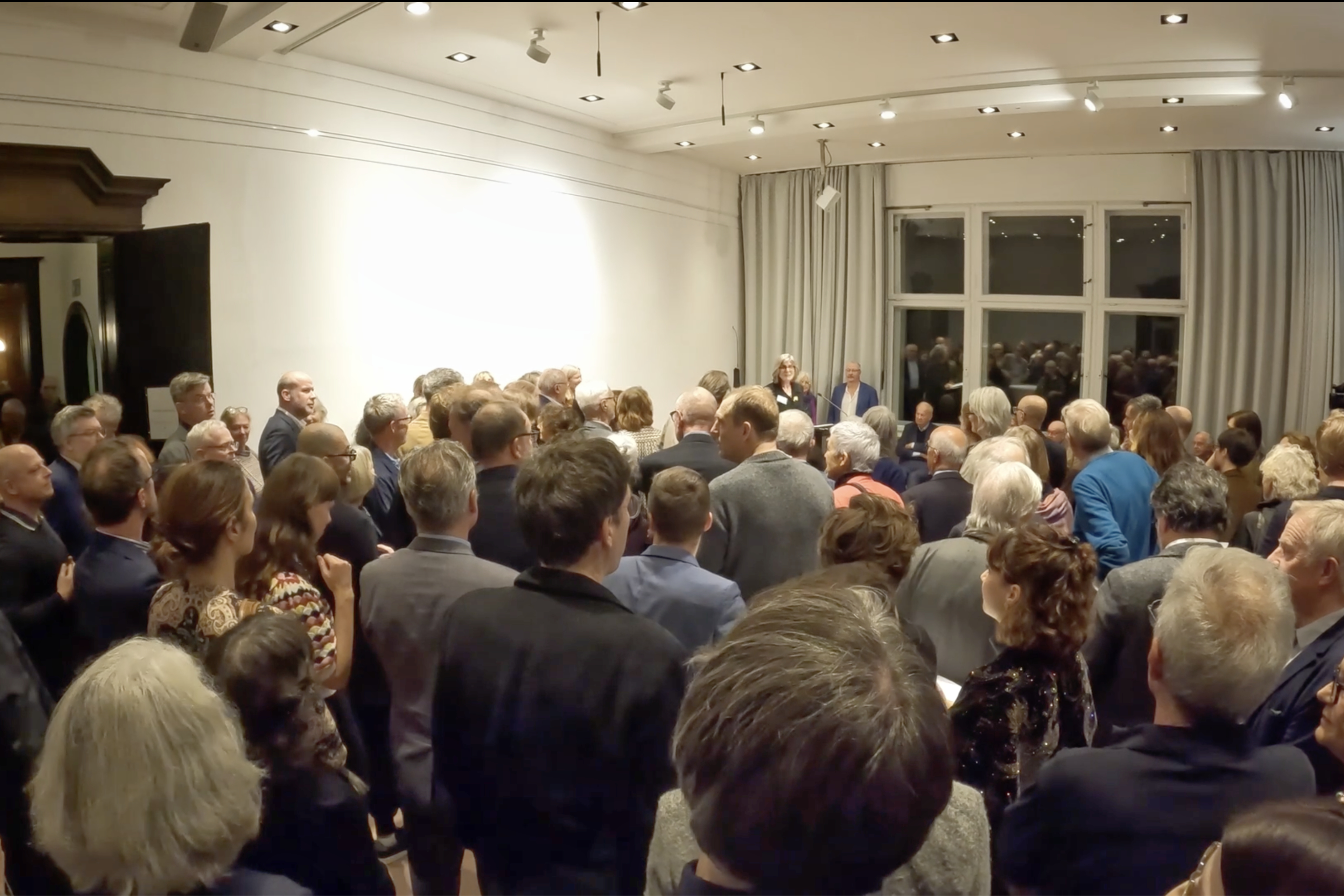 Ein Raum voller Menschen, die mit dem Rücken zur Kamera stehen