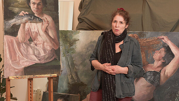 Roni Taharlev in front of her paintings