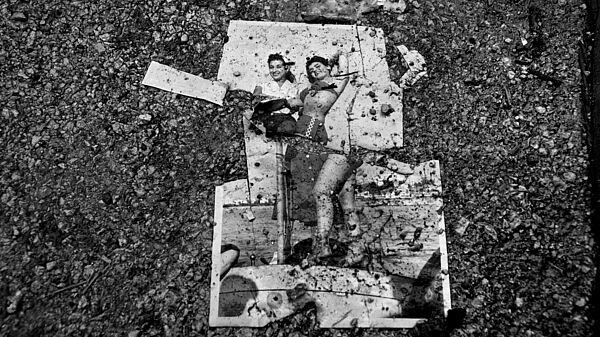 Torn photo on asphalt © Fouad Elkoury