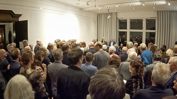 Ein Raum voller Menschen, die mit dem Rücken zur Kamera stehen