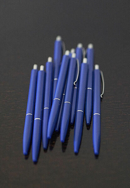 Blue pens on a dark table
